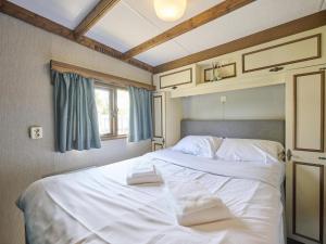 a bedroom with a bed with white sheets and a window at Zomerzoet in Brouwershaven +70 photos