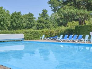 a swimming pool with chairs and a table at Zomerzoet in Brouwershaven