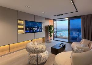 a living room with two chairs and a tv at Panoramic Nile View 3BR Apartment in Cairo