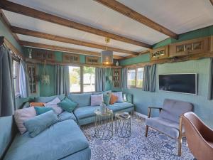 a living room with a blue couch and a tv at Zomerzoet in Brouwershaven