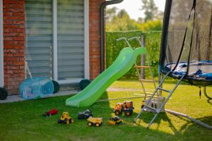 a playground with a green slide and toys in the grass at Odmaraliste Paradise14 - Private Villa with Heated Pool & Jacuzzi in Rainci Gornji