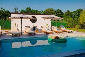 a swimming pool with chairs and umbrellas and a swimming pool at Odmaraliste Paradise14 - Private Villa with Heated Pool & Jacuzzi in Rainci Gornji