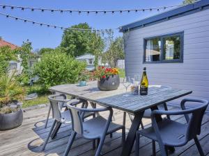 a picnic table with chairs and a bottle of wine at Zomerzoet in Brouwershaven