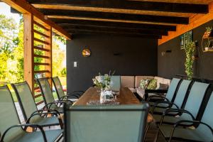 a wooden table and chairs on a patio at Odmaraliste Paradise14 - Private Villa with Heated Pool & Jacuzzi in Rainci Gornji