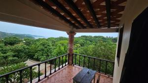 a balcony with a table and a view of the forest at Hotel Casa Huijazoo in Mazunte