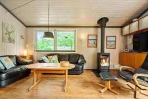 a living room with a table and a fireplace at 8159-Praesto-Vagtelvej-8 in Præstø
