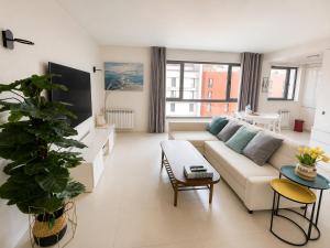 a living room with a couch and a table at Bom dia Parque Nações Lisboa W in Lisbon
