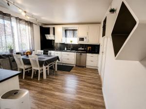 a kitchen and dining room with a table and chairs at Lägenhet med trädgård på Österlen, nära hav & golf in Gärsnäs