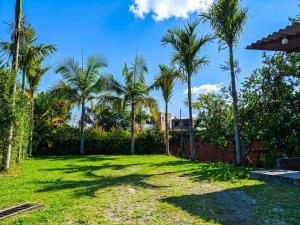 a lawn with palm trees in a yard at ISA BELLA Hospedaje y Cabaña Entre Aves in Luna Park