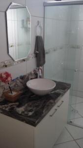 a bathroom with a sink and a mirror on a counter at Pousada Brasil Tropical in Bezerros