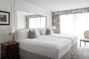a large white bed in a room with a window at Wedgewood Hotel & Spa - Relais & Chateaux in Vancouver