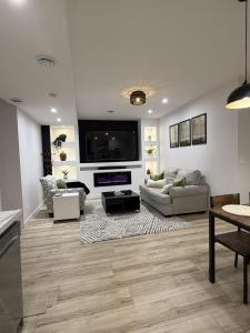 a living room with couches and a flat screen tv at The Ogieva Suites in Airdrie