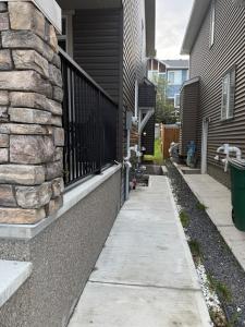 a sidewalk outside of a house with a fence at The Ogieva Suites in Airdrie