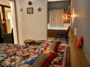a bedroom with a bed with a quilt on it at Flat com Jacuzzi em Capitólio - Cantinho do Lago 1 in Capitólio