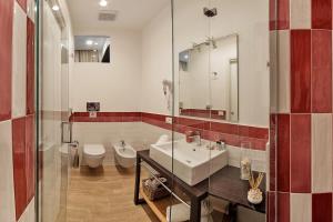 a bathroom with a sink and a toilet and a mirror at Dea Guest House in Sorrento