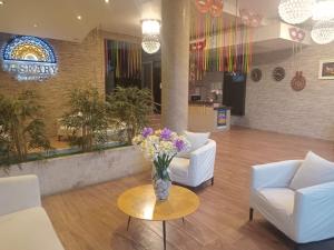 a lobby with two couches and a vase of flowers on a table at Paskary Hotel in Cajamarca