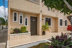 a house with a black door on a street at Home 365 Mérida Comodidad, amplitud total, 3 recamaras, 2 baños 5 camas ideal familias Consulado Americano in Mérida