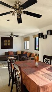 a living room with a table and a ceiling fan at Home 365 Mérida Comodidad, amplitud total, 3 recamaras, 2 baños 5 camas ideal familias Consulado Americano in Mérida