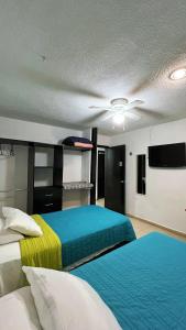 a bedroom with two beds and a ceiling fan at Home 365 Mérida Comodidad, amplitud total, 3 recamaras, 2 baños 5 camas ideal familias Consulado Americano in Mérida
