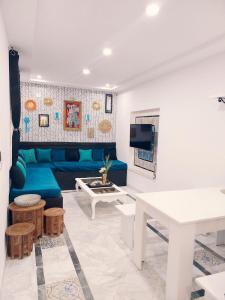 a living room with a blue couch and a table at House Near the Sky in Dar Salah Bey