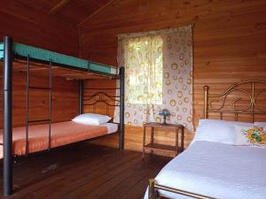 a bedroom with two bunk beds and a window at Eco-Cabañas Altozano Nimaima in Nimaima