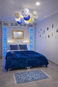 a bedroom with a large bed with blue sheets and chandeliers at House Near the Sky in Dar Salah Bey +46 photos