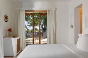 a bedroom with a bed and a sliding glass door at Villa Praia - La Villa Group in Jericoacoara +168 photos