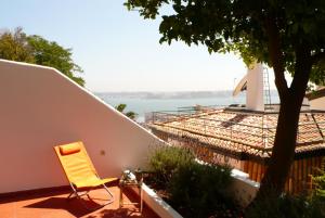 una sedia gialla seduta su un patio accanto a un edificio di Apartment terrace Castelo S.Jorge a Lisbona