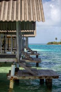 a wooden pier with a building on the water at Cabañas Wailidub, San Blas in Ogobsitupo