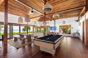 a living room with a pool table and ping pong ball at Marbella Mentawai Beachfront Private Villa Sleeps 10 in Katiet
