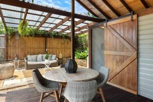 a patio with a wooden door and a table and chairs at Mini Mullum Studio Retreat in Mullumbimby