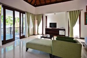 a living room with a couch and a tv at Chads Dive Resort Lembeh in Bitung