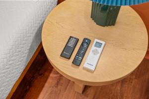 a table with three remote controls on it at Madeira Cottage - Amphitheater in St. Augustine
