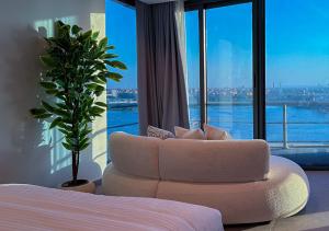 a bedroom with a white couch in front of a window at Panoramic Nile View 3BR Apartment in Cairo