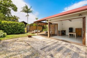 a house with a red roof and a patio at Mini Mullum Studio Retreat in Mullumbimby