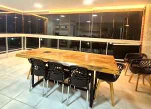 a kitchen with a wooden table and chairs at Salt Beach Atalaia Fort do Farol in Salinópolis