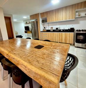 a large kitchen with a wooden table and chairs at Salt Beach Atalaia Fort do Farol in Salinópolis