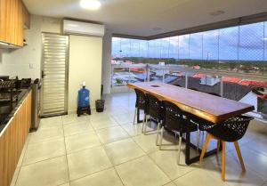 a kitchen with a wooden table and chairs on a balcony at Salt Beach Atalaia Fort do Farol in Salinópolis +51 photos