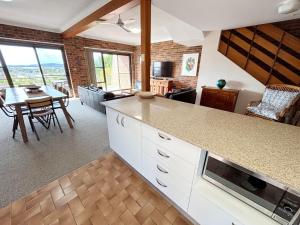 a kitchen with a counter and a dining room at Seaview Townhouse 2 - Bring your own linen. in South West Rocks