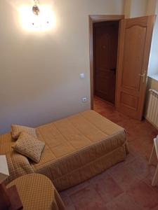 a bedroom with a bed and a wooden door at La Ribera del Río in Trefacio