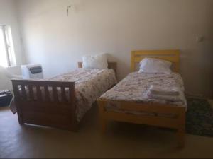 a bedroom with two beds and a window at Aroma das Tílias in Proença-a-Nova