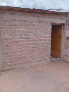 a brick wall with a door in a garage at casa domo in Maimará +2 photos