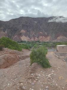 a building in the middle of a desert with mountains at casa domo in Maimará