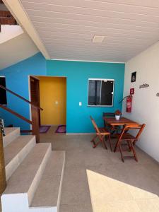 Ein Zimmer mit Tisch und Stühlen und blauen Wänden in der Unterkunft Chalés do mar in Icapuí