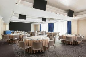 a conference room with tables and chairs and a screen at Courtyard by Marriott Rome Central Park in Rome