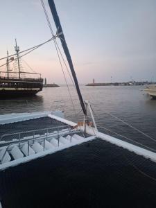 a boat in a body of water with a dock at Balade de 3 heures en Catamaran de Luxe djerba in Houmt Souk
