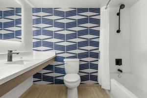 a bathroom with a toilet and blue and white tiles at City Express By Marriott Findlay in Findlay