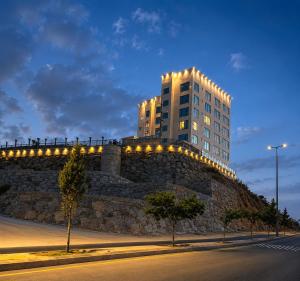 a building on top of a stone wall with lights at wifad Hotel in Al Namas