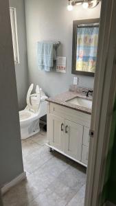 a bathroom with a toilet and a sink and a mirror at Journey House LA in Los Angeles