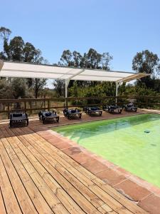 a swimming pool on a wooden deck with a pavilion at Herdade do Corval in Reguengos de Monsaraz